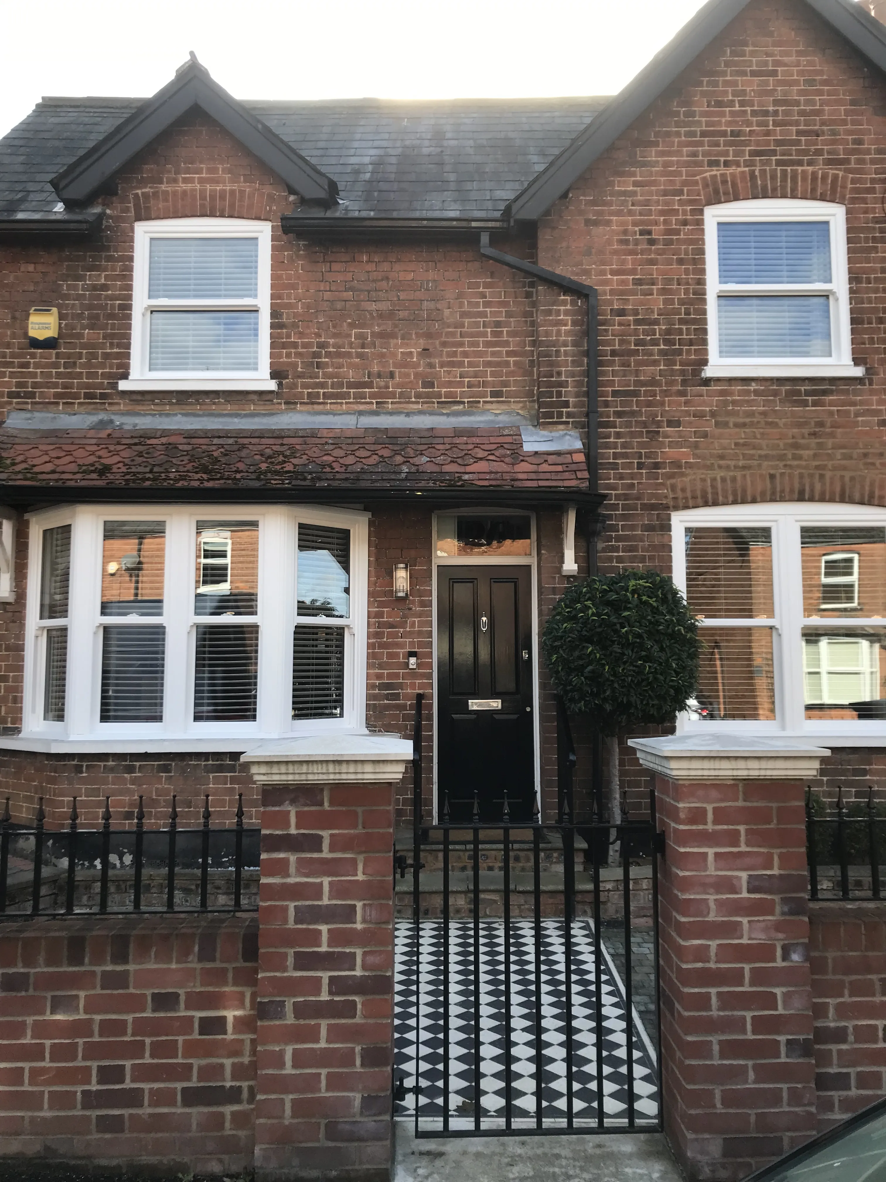 White ECOSlide vertical sash windows and a ground-floor bay on a brick home