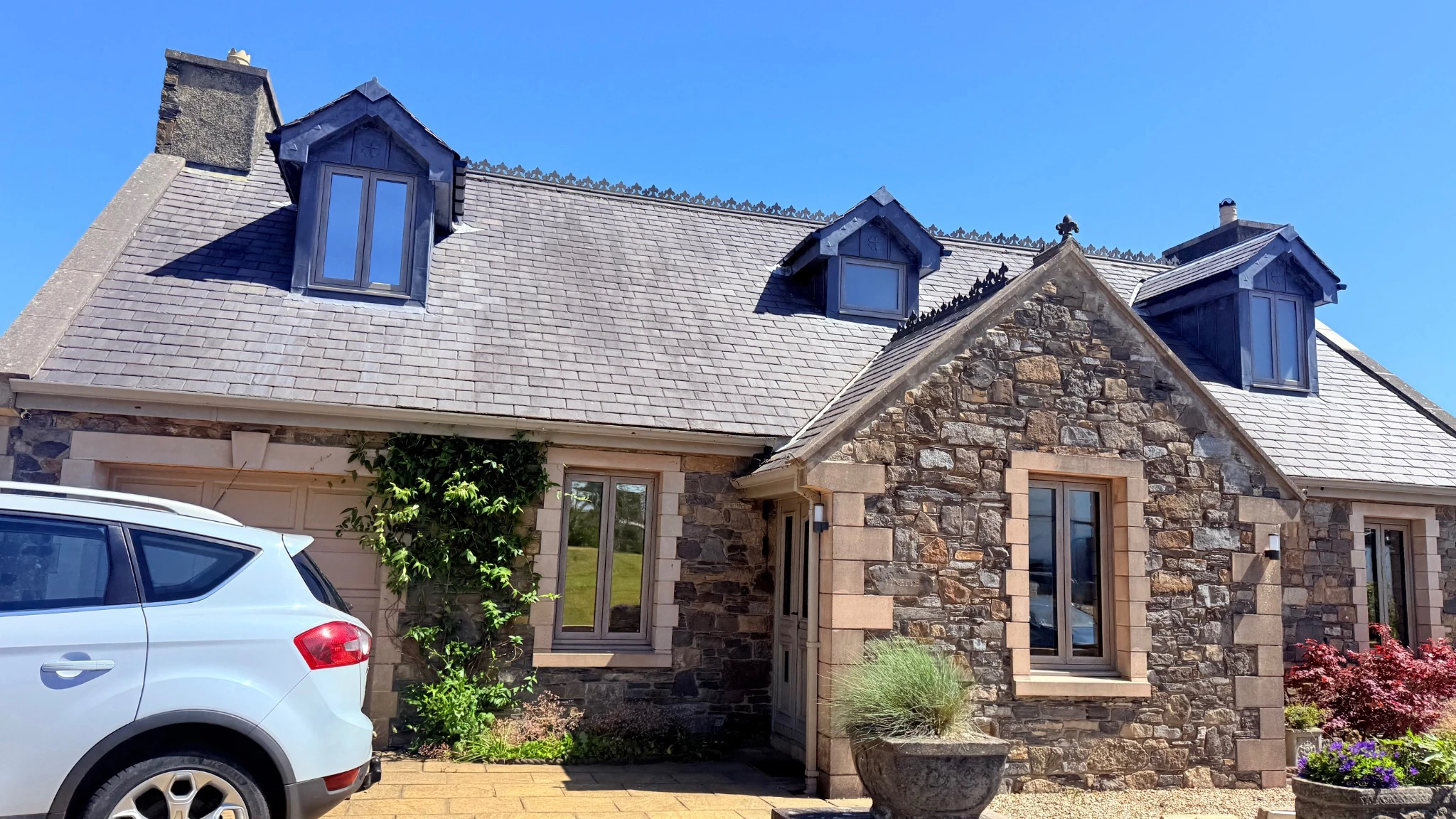 Flush-sash windows fitted by DPM on a stone-built home with slate dormers